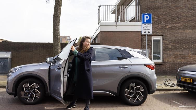 Persoon staat bij deelauto