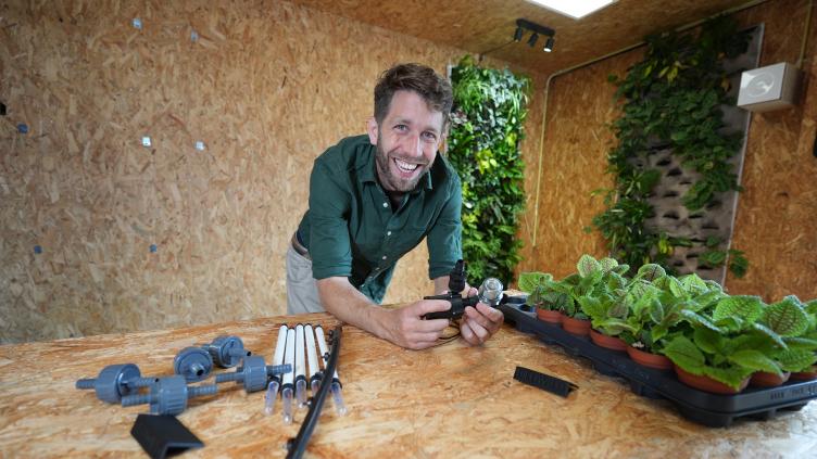 Quinten van Duin staat achter een werktafel met plantjes