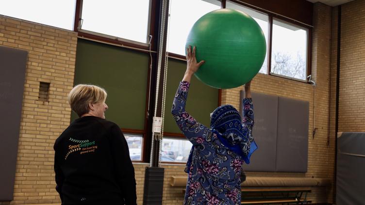 Twee vrouwen doen een oefening met een grote bal