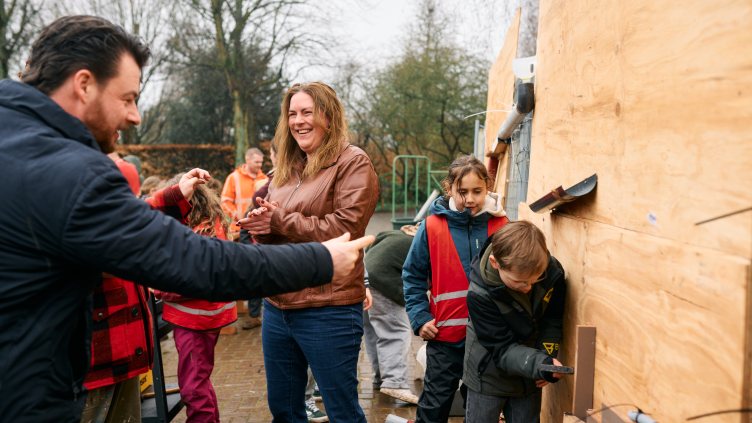 Wethouders RobWethouders Robbert Berkhout en Eva de Raadt helpen kinderen met de bouw van een knikkerbaan van restmaterialen.