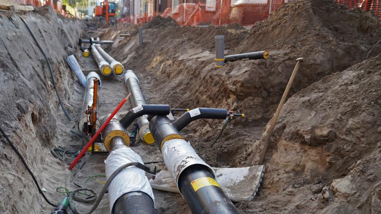Buizen worden in de grond geplaatst voor de aanleg van een warmtenet
