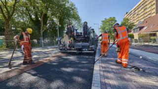 Wegwerkers werken aan duurzaam asfalt op de Prof Eijkmanlaan