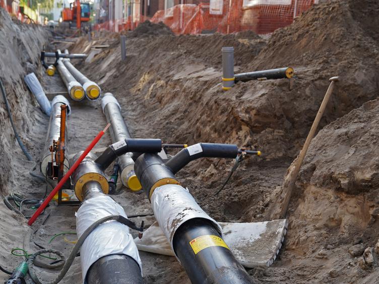 Buizen worden in de grond geplaatst voor de aanleg van een warmtenet