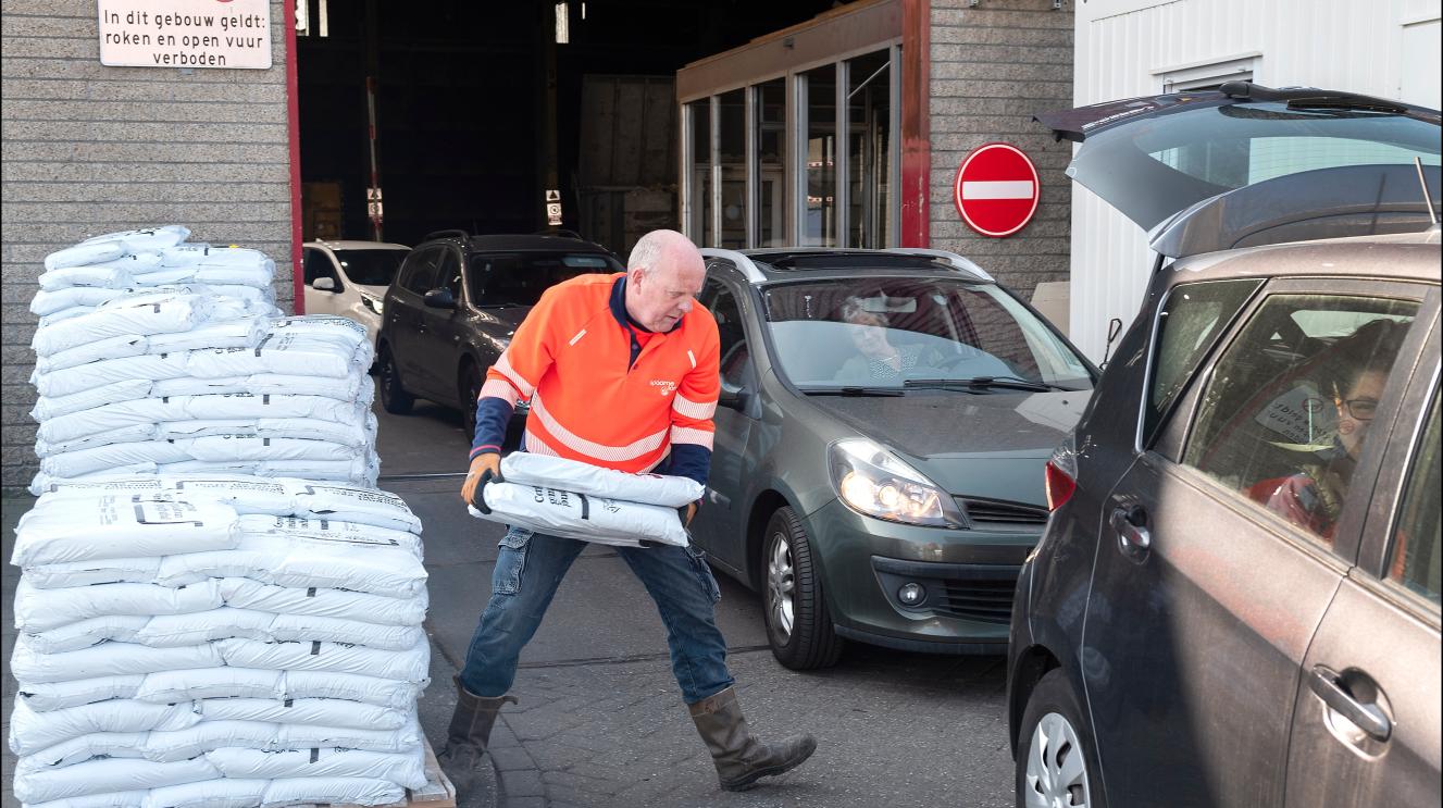Medewerker van Spaarnelanden sjouwt met zakken compost
