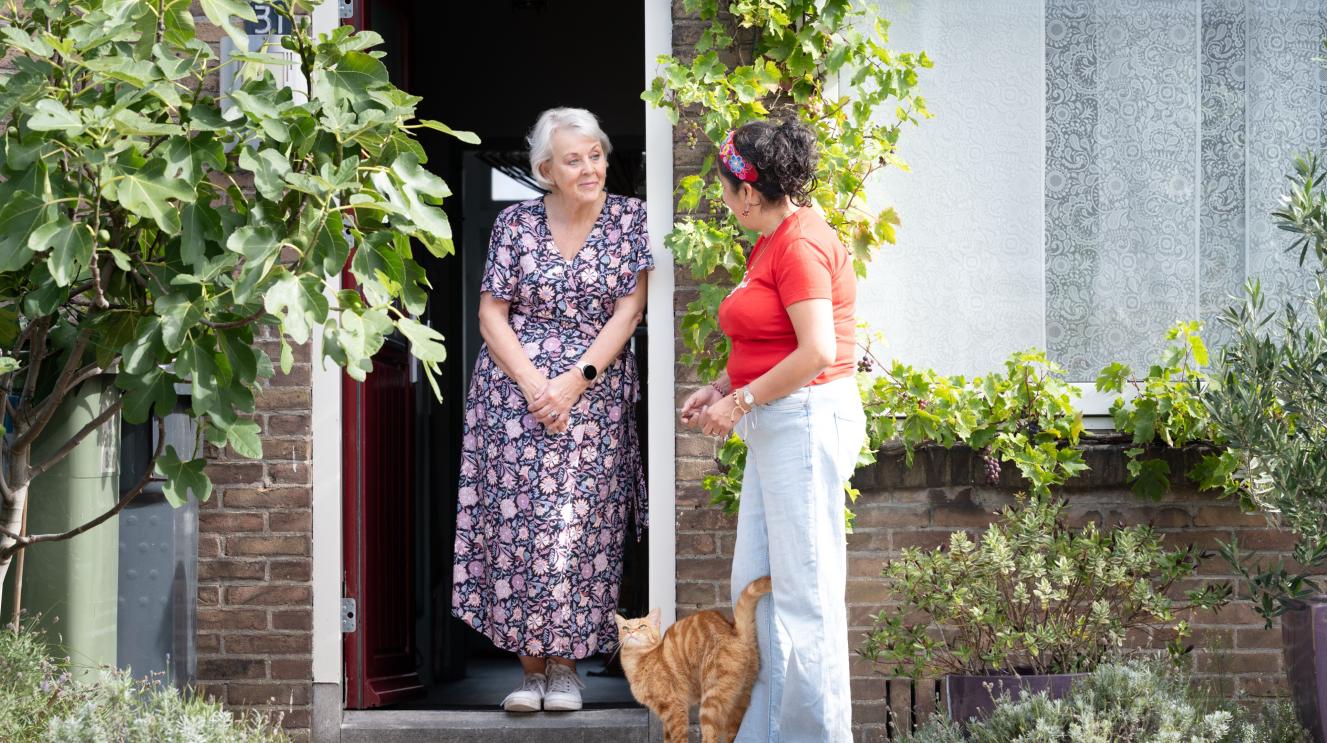 2 vrouwen met elkaar in gesprek aan de voordeur