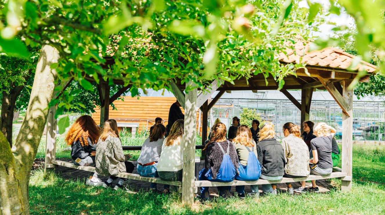 Jongeren buiten onder een dak in Vrij Waterland