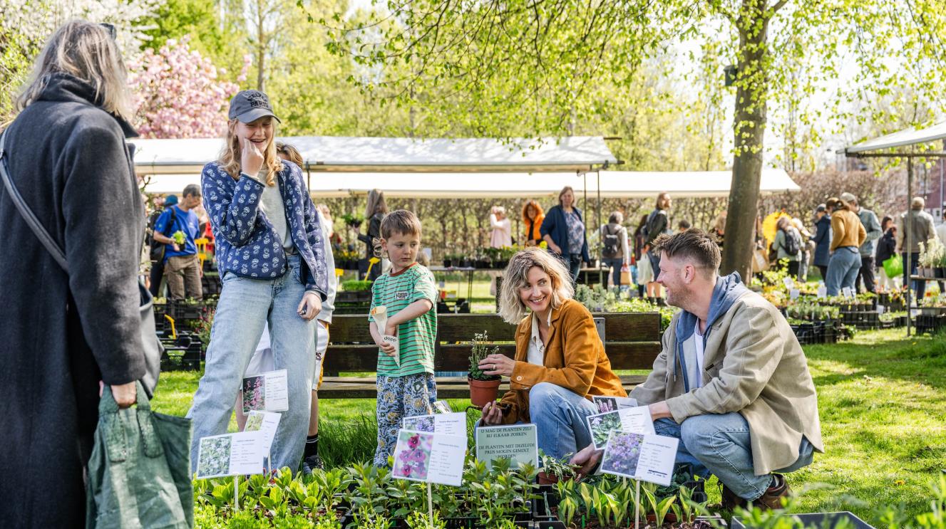Man, vrouw en 2 kinderen op een plantjesmarkt