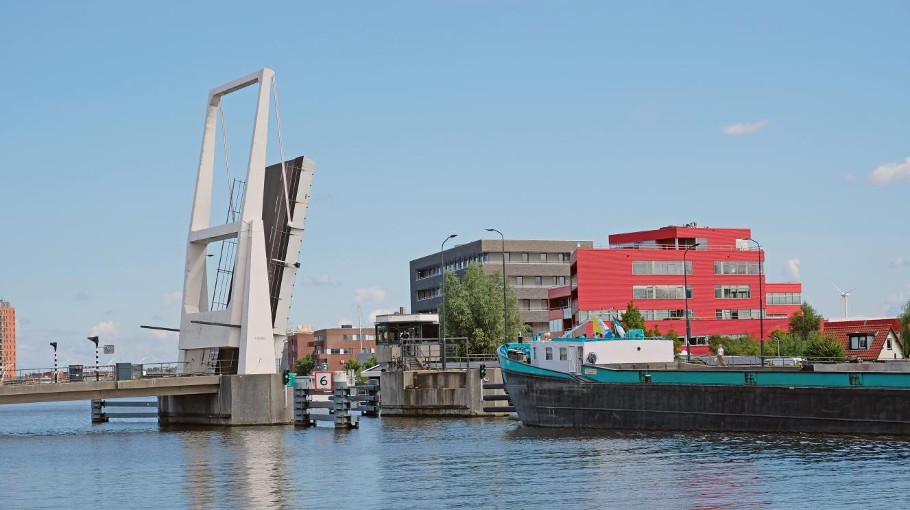 Een schip vaart onder de openstaande Waarderbrug 