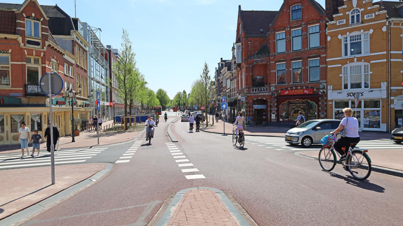 Fietsers, voetgangers en een auto bij het Houtplein