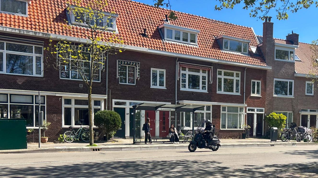 Iemand op een scooter rijdt voor een bushalte langs