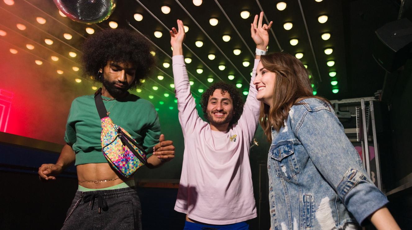 3 jongeren dansen in een club