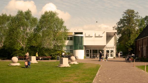 Vooraanzicht van het huidige witte NME gebouw in de Haarlemmer Kweektuin