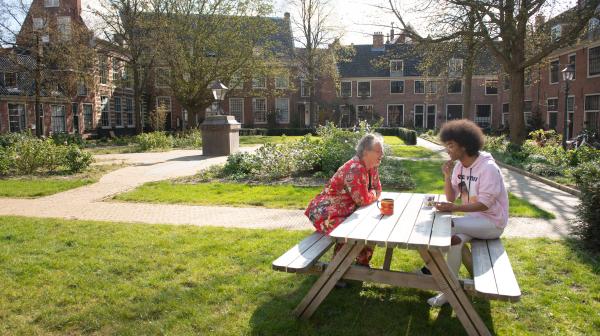 2 personen in gesprek aan een tafel in het Proveniershof