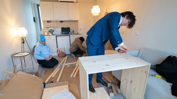 Oekraïners zetten samen met wethouder Floor Roduner meubels in elkaar