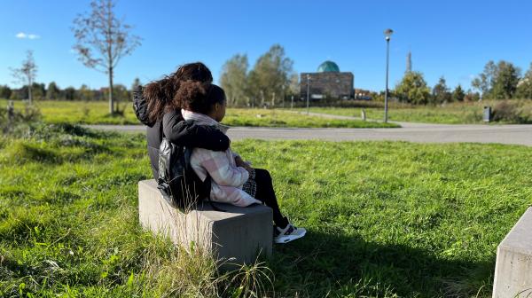 Meisje en pleegmoeder op een bankje in het park. 