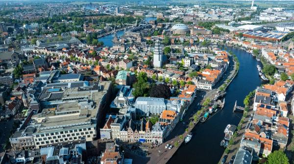 Foto van Haarlem vanuit de lucht met in het midden het Spaarne en in de verte de Koepel