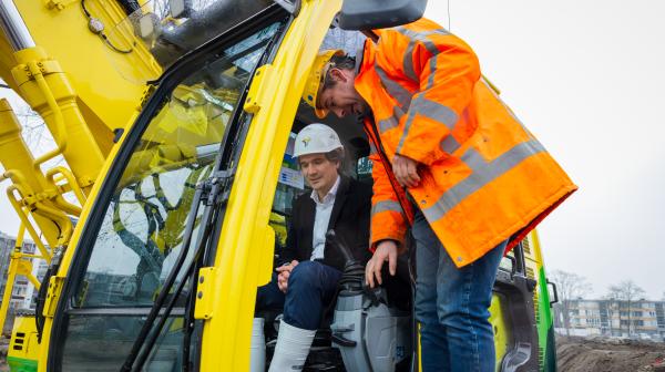 Wethouder Roduner en een werkman op een graafmachine